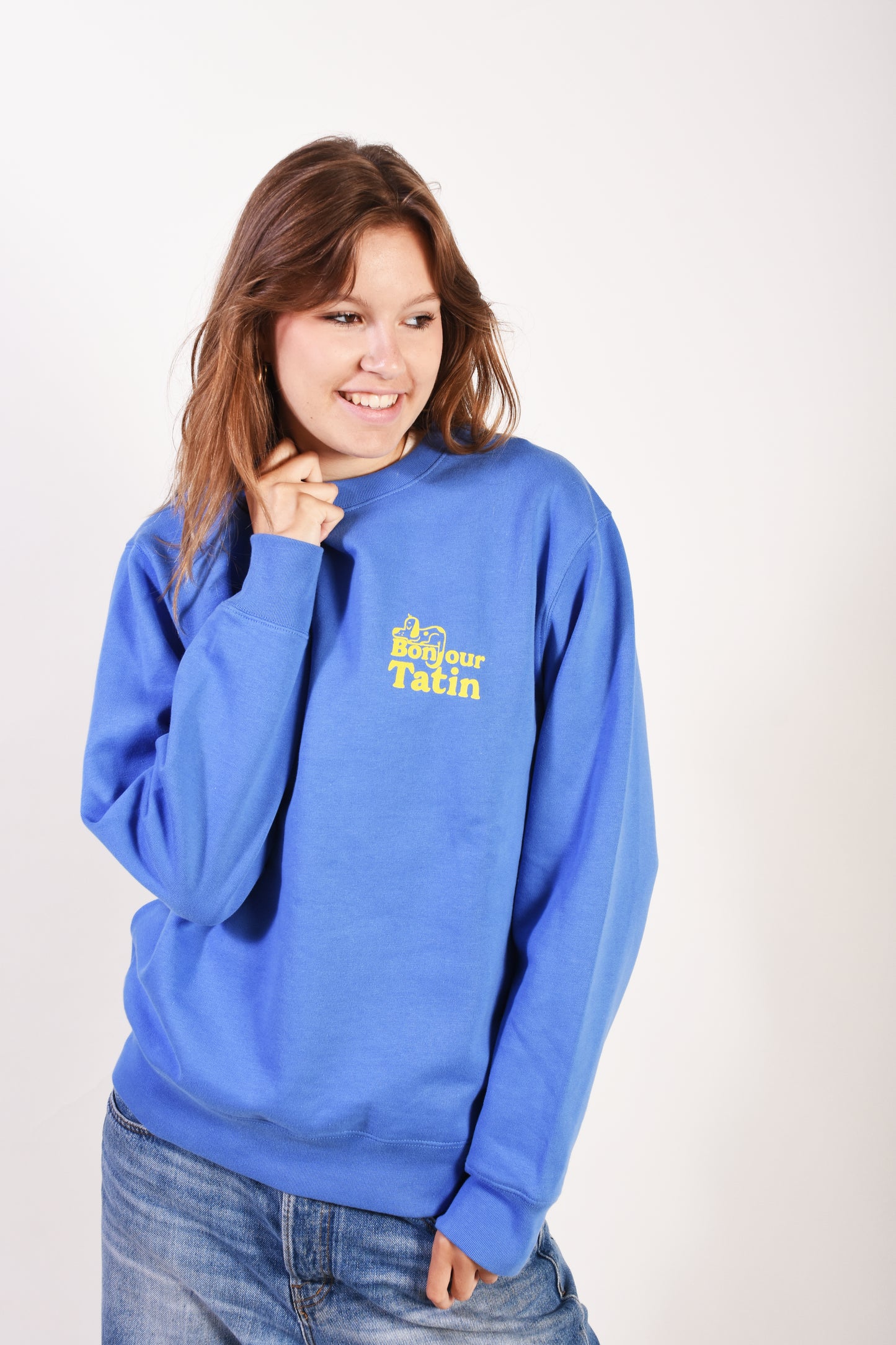 teenage girl wearing a blue hoodie with a logo on a white background